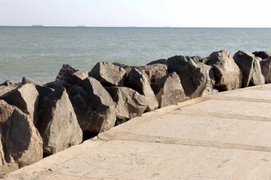 Modern dalgakıran tasarımı ile büyük taş ve beton döşeme özel dalga kıran tasarım hücrelerle Close-up. İskele beton ve taş bloklarla sahil korumaya. Shore konsolidasyon