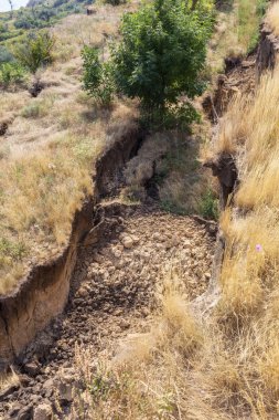 Sesmically tehlikeli bölgede dağ heyelan felaketi. Toprak, toprak engelleme yolun büyük katmanları kökenli büyük çatlaklar. İnsanlara heyelan pistlerinin dağın damming, ölümcül bir tehlike
