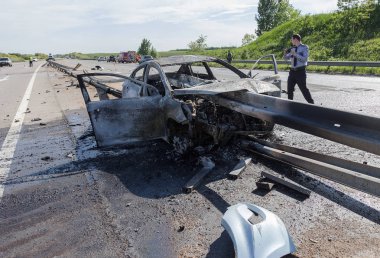 Odessa, Ukrayna - 17 Mayıs 2018: kaza yüksek hızlı yolda. Yüksek hızda sürdü Road arabaya korumak ve yandı. Aşırı hız nedeniyle korkunç trajik kaza. Otomatik yol emniyet görevlisi ayıran içine çöktü