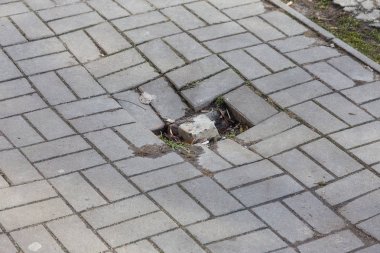 Çukurlar, kışın donma-çözülme çevrimleri neden olan bozuk asfalt yol. Kötü yol. Kaldırımlar kaldırımlar kaldırımda kırık. kaldırım döşeme ile kusurları ile tabaka ve perspektif içinde gelen çatlaklar