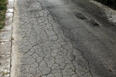 Bozuk asfalt yol çukurların, eski taş yol, kaldırım taşı, kaldırım taşı döşeli. Kötü yol tehlikelidir. Yaya yolu üzerindeki kırık parke döşeme