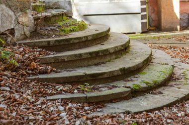 Eski, açık, taştan bir merdiven. Taş, eski merdivenlerin çimento basamaklarında yıpranma ve yıpranma izleri var. Eski taş bir merdiven, eski kırık basamaklar. Seçici odak