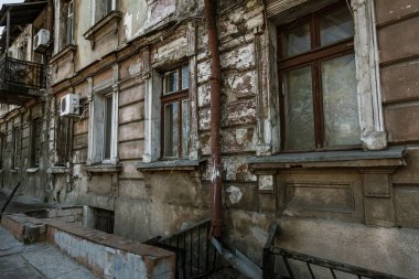Bir close-up dokulu bir arka plan paslı Rus düşürür. Yağmur olukları bir eski terk edilmiş evde. Paslı borusuna zavallı çeyrek evin kirli duvardaki delik
