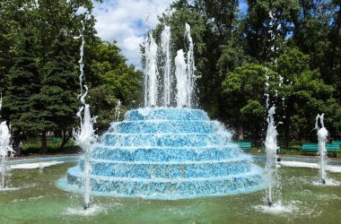 Şehir çeşme. Şehir Parkı bir sıcak yaz gününde çeşme. Su, damla ve güzel bir şehir çeşme su parlak su sıçramalarına akış. Parlak gün şehir Çeşme köpüklü su streams