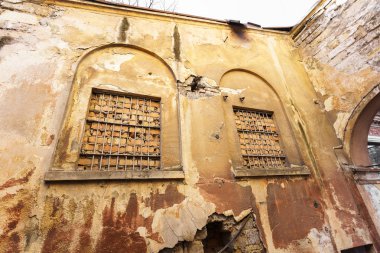 Zavallı çeyreğinde konut binasının kirli, yıkık duvar ahşap çerçeve ile eski bir pencere. Yıkım ve yoksulluk yaratıcı arka plan. Eski ahşap kırık pencere yıpranmış binanın duvarındaki