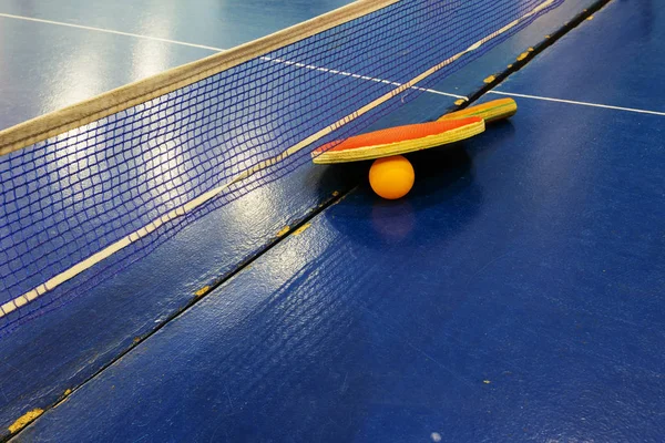 Table tennis ping-pong. A table tennis racket with plastic ping pong ball on gaming table. Sports background of table sport game in ping-pong. A tennis racket, a tennis ball on the gaming table