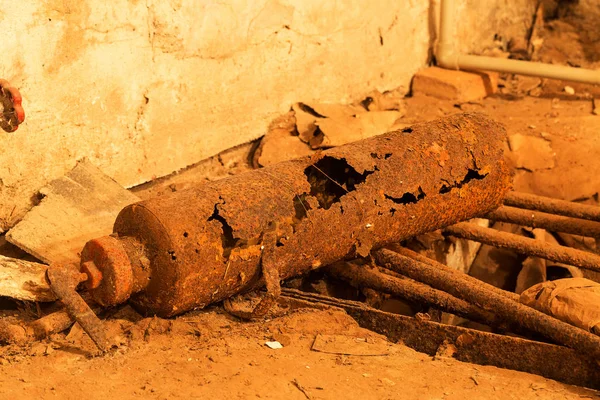 old boiler room in the basement. Abandoned interior of an industrial building. old damaged boiler room. Old rusty pipes. Rusty metal, rusted to holes, old abandoned iron fire extinguisher