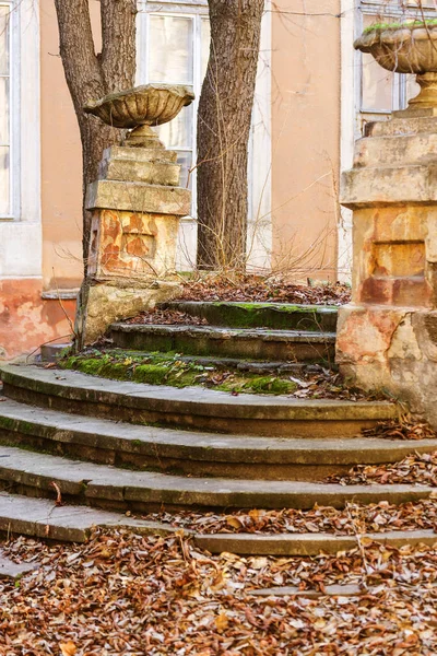 An old open outer stone staircase. Stone, cement steps of the old staircase with traces of weathering and destruction. An ancient stone staircase, ancient broken worn steps. Selective focus