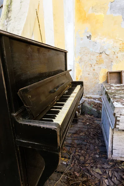 破坏的老钢琴在街上 复古老钢琴在一个鬼城的露天废弃的场景 一个破碎的木制场景与破碎的黑色钢琴 黑色钢琴特写镜头 — 图库照片