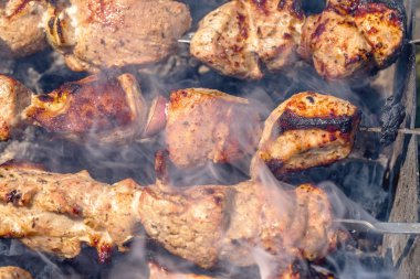 parlak, temiz hazır appetinye kebap ızgarada hazırlanan kömürlerin üzerinde şiş üzerinde buhar kokulu duman bulutları içinde mangal. seçici odak ile fotoğraf. Restoran ve Cafe menü için bir reklam olarak