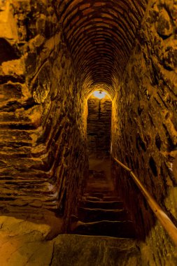 Bir dar taş merdiven bir ortaçağ kalesi eski Hıristiyan manastır Rila, Bulgaristan kulesinde. Taş duvarlı gizemli kasvetli tünel