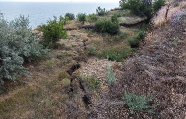 Sesmically tehlikeli bölgede dağ heyelan felaketi. Toprak, toprak engelleme yolun büyük katmanları kökenli büyük çatlaklar. İnsanlara heyelan pistlerinin dağın damming, ölümcül bir tehlike