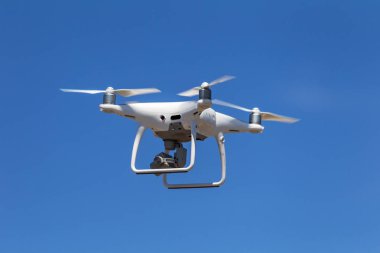 Profesyonel hava dron video kamera görüntüleri yukarıdan vuruyor. Büyük beyaz helikopter Uçak yüksekten mavi gökyüzünde uçuyor. Casus helikopter havada sinek kablosuz uzaktan kumanda ile