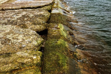 Kıyı beton koruyucu yapı yok. Döşeme blokları arasında büyük derin çatlaklar shore dalga deniz etkisinin erozyon korumak. Beton takviye sahil korumaya ile büyük parçalar