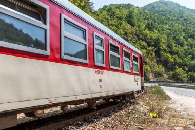 Bansko, Bulgaristan -29 Temmuz 2016: küçük retro rock Tren Garı yolcu sırt boyunca geçmiş dağ yolu virajlı yıpranmış eski dar hat raylar üzerinden taşır