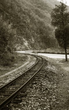 Eski demiryolu Pirin Dağları'nda dar. Dramatik doğal sahne. Demiryolu sonbahar dağ manzarası. Bulutlu bulutlar dağlar üzerinde. Yoksul ülkelerde seyahat kavramı. Retro tarzı