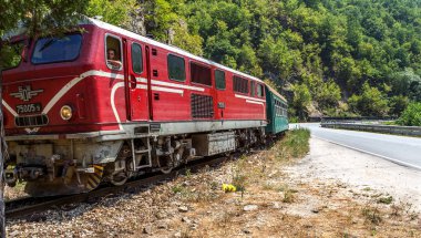 Bansko, Bulgaristan -29 Temmuz 2016: küçük retro rock Tren Garı yolcu sırt boyunca geçmiş dağ yolu virajlı yıpranmış eski dar hat raylar üzerinden taşır