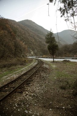 Eski demiryolu Pirin Dağları'nda dar. Dramatik doğal sahne. Demiryolu sonbahar dağ manzarası. Bulutlu bulutlar dağlar üzerinde. Yoksul ülkelerde seyahat kavramı. Retro tarzı