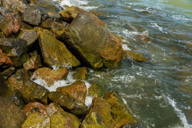Granit taş kõyõ alanlarõ ve akış aşağı kum Beach sakin mola sırasında yumuşak küçük dalgalar. Dalga deniz köpük buzlu karşı bozuldu. Dalga düşme ve çöl beac kıyısında boyunca akar