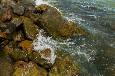 Granit taş kõyõ alanlarõ ve akış aşağı kum Beach sakin mola sırasında yumuşak küçük dalgalar. Dalga deniz köpük buzlu karşı bozuldu. Dalga düşme ve çöl beac kıyısında boyunca akar