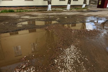 Teknoloji yollarının yapımı ihlalleri nedeniyle aşırı soğuk ve ağır yağmurlar asfalt yol yıkadı ve çok sayıda çatlaklar ve tehlikeli hataları kurdu
