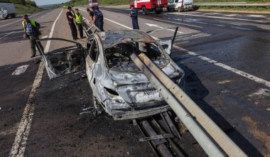 Odessa, Ukrayna - 17 Mayıs 2018: kaza yüksek hızlı yolda. Yüksek hızda sürdü Road arabaya korumak ve yandı. Aşırı hız nedeniyle korkunç trajik kaza. Otomatik yol emniyet görevlisi ayıran içine çöktü