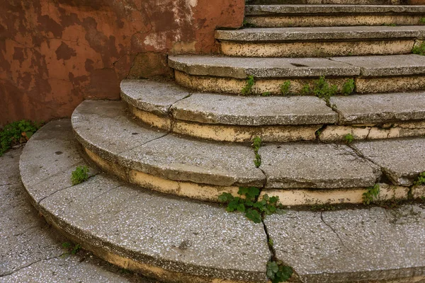 Eski, açık, taştan bir merdiven. Taş, eski merdivenlerin çimento basamaklarında yıpranma ve yıpranma izleri var. Eski taş bir merdiven, eski kırık basamaklar. Seçici odak