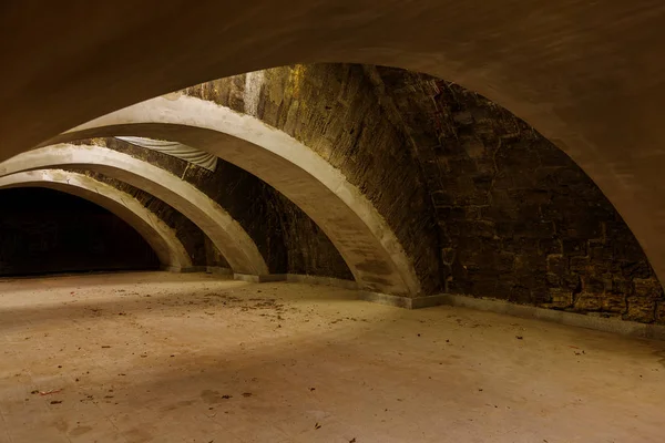 An old abandoned tunnel in an underground wine cellar. Entrance to catacombs. Dungeon Old stone fortress. As creative background for staging dark design. Mystical interior of ancient dungeon