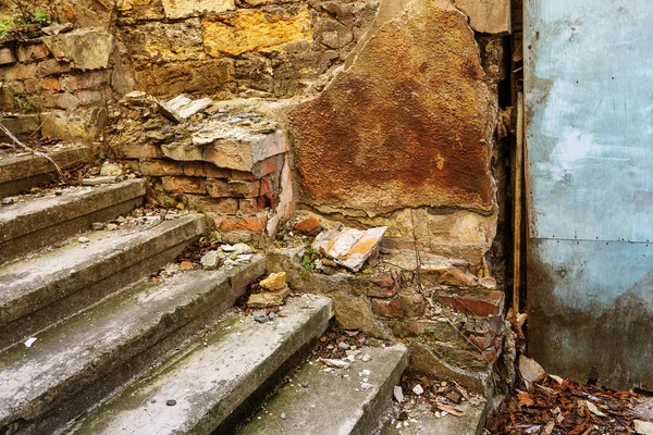 An old open outer stone staircase. Stone, cement steps of the old staircase with traces of weathering and destruction. An ancient stone staircase, ancient broken worn steps. Selective focus