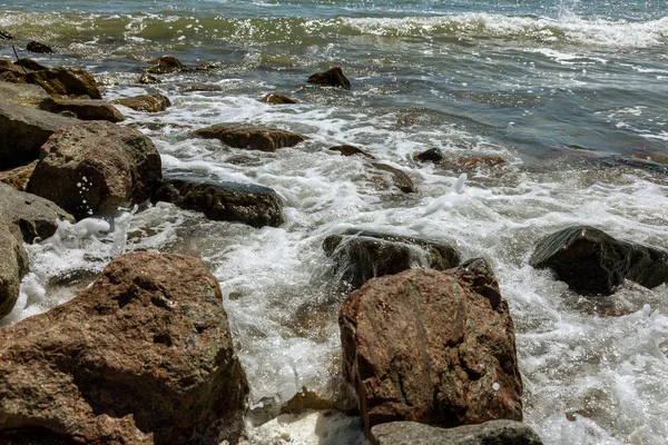 在沿海地区的花岗岩石头上平静地休息时 软软的小浪 沿着海滩的沙子流动 海波被打破对岩石与泡沫 海浪落在沙漠 Beac — 图库照片