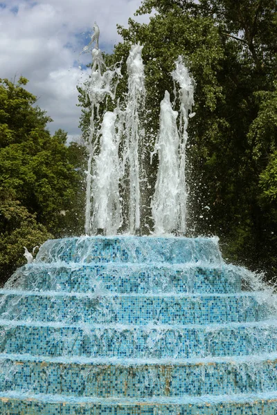 市内の噴水 夏の暑い日に公園の噴水 美しい街の噴水の水の明るい水しぶき 滴水のストリーム 日市泉に輝く水の明るいストリーム — ストック写真