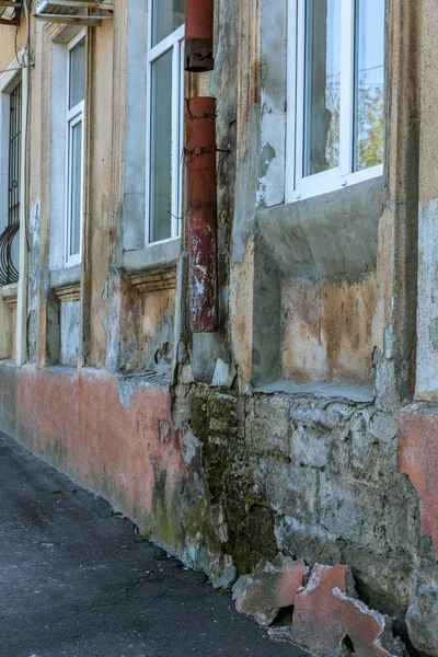 在质感背景上的锈迹斑斑的俄罗斯排水沟的特写镜头 在一座废弃的老房子里 雨水排水沟 贫穷小区房子脏墙排水管上的锈迹斑斑的洞 — 图库照片
