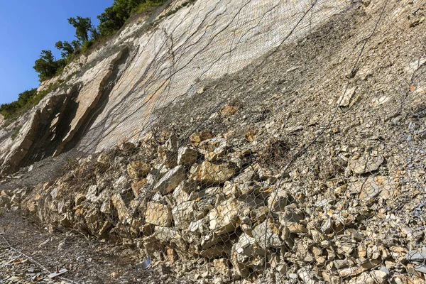 特別な金属メッシュで道路の近くで斜面危険な山を強化します 山スラウから道路の落石ネット フェンスを抑制累積金属保護 — ストック写真