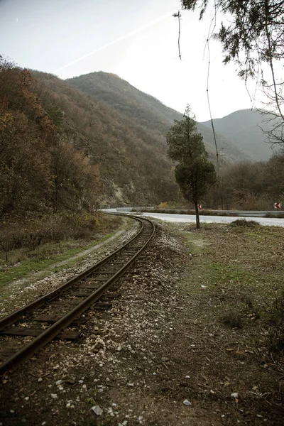 Eski demiryolu Pirin Dağları'nda dar. Dramatik doğal sahne. Demiryolu sonbahar dağ manzarası. Bulutlu bulutlar dağlar üzerinde. Yoksul ülkelerde seyahat kavramı. Retro tarzı
