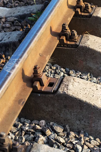 Old railroad tracks in perspective. Old rails in landscape. Rails in land. Rail track in center of page at forefront. The construction of railway line for tram with rails, gravel and underlay sleepers