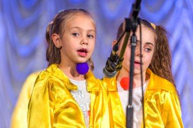 Odessa, Ukrayna - 24 Aralık 2015: şarkı ve parlak renkli kıyafetler içinde sahnede dans çocuk müzik grupları. Duygusal, çocukların müzik sahne gösterisi dokunmadan.