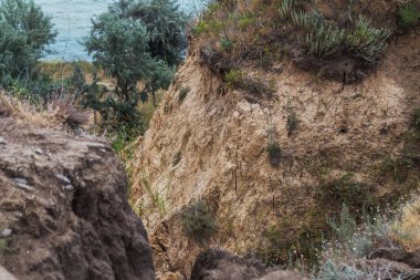 Çevreye zararlı bir bölgede dağ heyelan. Yeryüzündeki büyük çatlaklar, toprak yolu kapatan büyük katmanların inişi. Dağ yamacının yamacında baraj tehlikesi