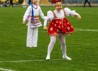 Odessa, Ukrayna - 21 Ekim 2017: Sahne alanı'nda çocuk. Genç çocuk topluluğu Stadyumu yeşil çimenlerin üzerinde Ulusal kostüm dans dans. Stadyumda dans çocuk