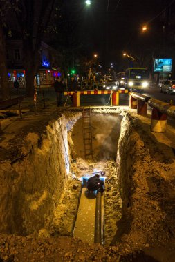 Odessa, Ukrayna - 10 Aralık 2015: inşaat işçileri Acil Onarım kentsel Karayolları geceleri mühendislik yapıyor. Onarım ve yedek su, Kanalizasyon borular alt kısmında derin bir siper gece boyunca. Kaza.