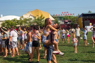 Odessa, Ukrayna - 5 Ağustos 2017: Gençler, bayanlar baylar bayram tatili sırasında birbirlerine renkli toz atma eğleniyorlar. Erkek ve kız ıslak giysileri içinde iyi eğlenceler. Islak parti