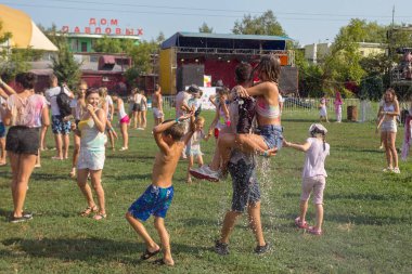 Odessa, Ukrayna - 5 Ağustos 2017: Gençler, bayanlar baylar bayram tatili sırasında birbirlerine renkli toz atma eğleniyorlar. Erkek ve kız ıslak giysileri içinde iyi eğlenceler. Islak parti
