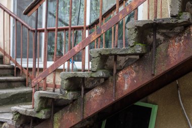 Eski, açık, taştan bir merdiven. Taş, eski merdivenlerin çimento basamaklarında yıpranma ve yıpranma izleri var. Eski taş bir merdiven, eski kırık basamaklar. Seçici odak