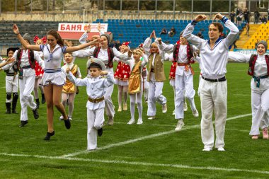 Odessa, Ukrayna - 21 Ekim 2017: Sahne alanı'nda çocuk. Genç çocuk topluluğu Stadyumu yeşil çimenlerin üzerinde Ulusal kostüm dans dans. Stadyumda dans çocuk