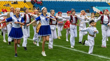 Odessa, Ukrayna - 21 Ekim 2017: Sahne alanı'nda çocuk. Genç çocuk topluluğu Stadyumu yeşil çimenlerin üzerinde Ulusal kostüm dans dans. Stadyumda dans çocuk