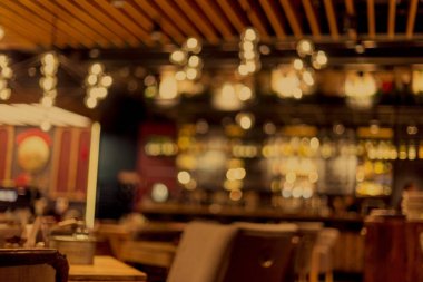 Küçük bir restoranın içi bulanık bir arka plan. Bokeh Kafe 'nin içini sıcak koyu renklerle bulanıklaştırmış. Yaratıcı moda tasarımı için arka plan olarak.