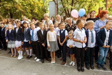 Odessa, Ukrayna 1 Eylül 2017: Okul bahçesinde öğrenciler ve öğretmenler ile okul çizgi var. Çocuklar okula geri dön. Bilgi gün, okulun ilk günü. Birinci sınıf öğrencileri sınıfta oturmak