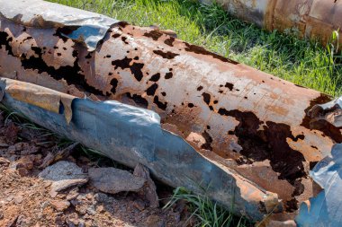 Eski büyük su boruları parçaları. Sonra uzun yıllar çalışma aşınmış metal boru yok. Paslı çelik boru delik metal korozyon ile. Seçici odak.