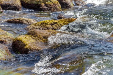 Büyük dalga sıçrama. Deniz suyu kayalar ve kayalıklarla karşı yenerek. Yukarıda ferahlatıcı güneş Zenit Beach'te mavi gökyüzü okyanus su damla.