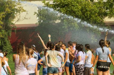 Odessa, Ukrayna - 5 Ağustos 2017: Gençler, bayanlar baylar bayram tatili sırasında birbirlerine renkli toz atma eğleniyorlar. Erkek ve kız ıslak giysileri içinde iyi eğlenceler. Islak parti