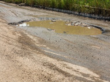 Asfalt yol ile çukurların dondurma ve çözme döngüsü sırasında belgili tanımlık kış nedeniyle zarar görmüş. Zavallı yol.